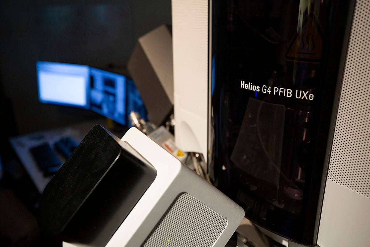A sleek piece of machinery sits next to some monitors.
