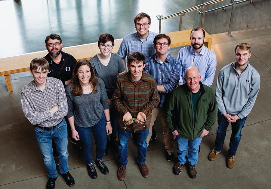 Ten people smile up at the camera.