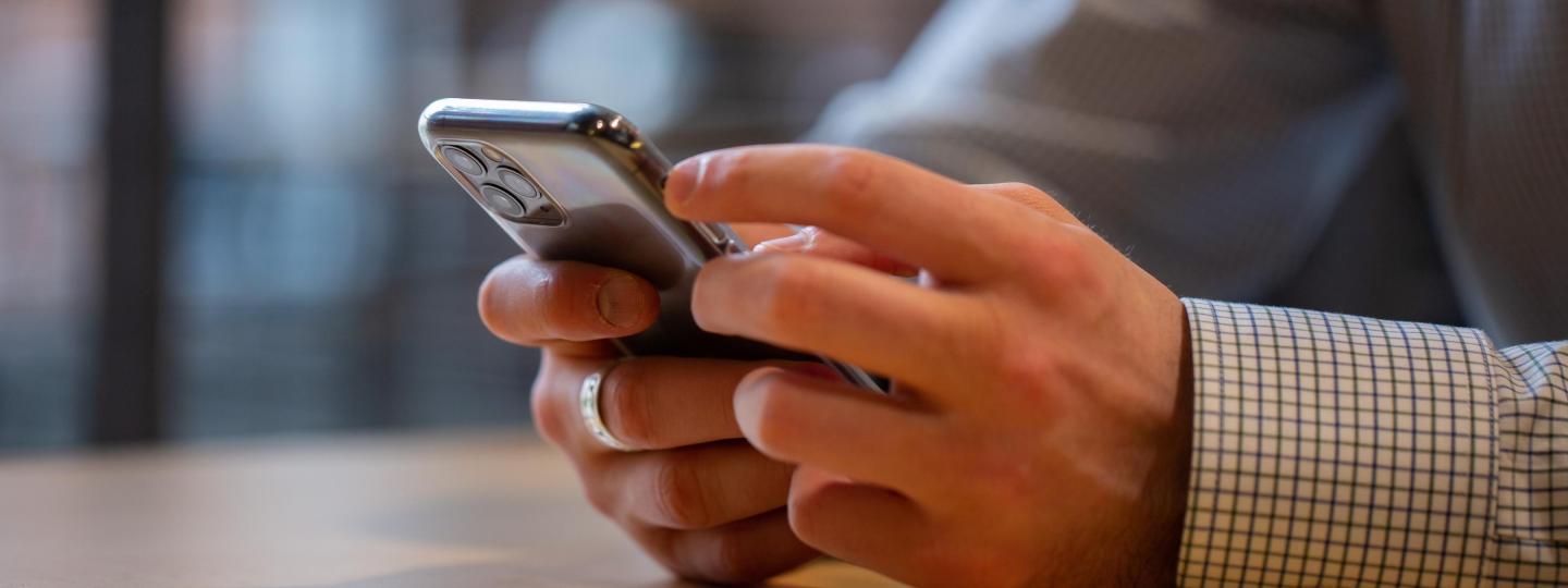 Close up of hands holding a cell phone. 