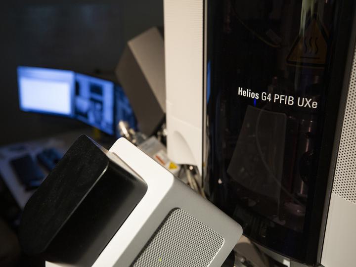 A sleek piece of machinery sits next to some monitors.